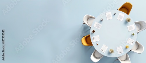 Top view of a modern conference room with a round table, documents, and white chairs, set on a light blue background.