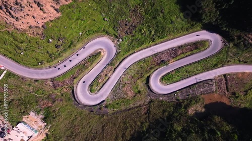 This aerial footage captures the winding roads of Ha Giang in Vietnam, as motorcycles navigate the and challenging terrain. The shot highlights the curves of the road and the beauty of the landscape.