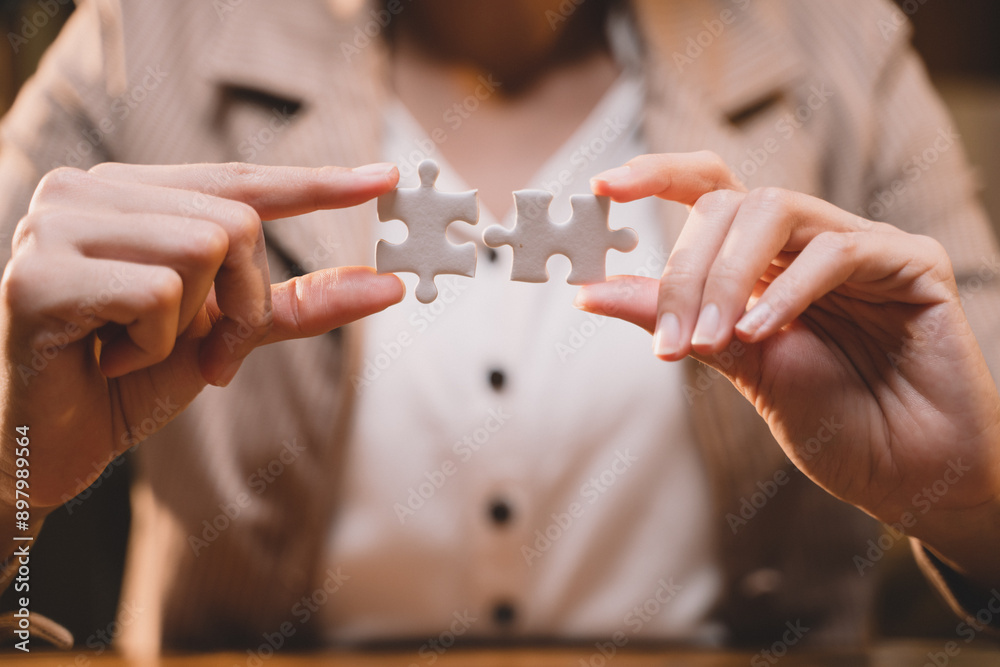 Close-up of business hands connecting jigsaw puzzle, success and goal achievement, the last jigsaw is the link of all the pieces. strategic planning or a solution for the management. Close-up of business hands connecting jigsaw puzzle, success and goal achievement, the last jigsaw is the link of all the pieces. strategic planning or a solution for the management.