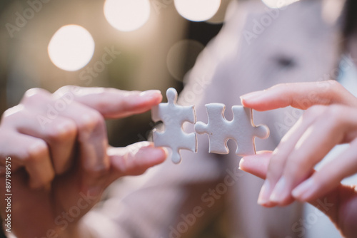 Close-up of business hands connecting jigsaw puzzle, success and goal achievement, the last jigsaw is the link of all the pieces. strategic planning or a solution for the management.