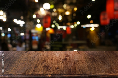 Empty dark wooden table in front of abstract blurred boken bankground of restaurant. Can used for display or montage your products. Mock up for space.