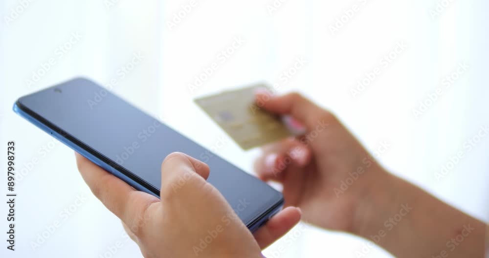 Mobile banking and online shopping. The girl is holding a phone and a bank card in her hands. Mobile banking and online shopping. The girl is holding a phone and a bank card in her hands.