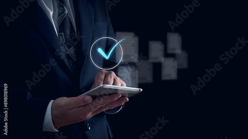 Businessman using tablet with guarantee check for client service, checkmark documents holographic symbolizing approval and verification, Client's service and guarantee check mark,quality management.