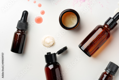 Assorted Skincare Products and Powder Spilled on a White Background