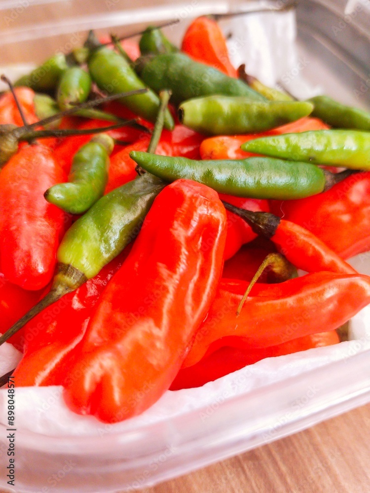 red chilies and green cayenne peppers in plastic containers in the kitchen red chilies and green cayenne peppers in plastic containers in the kitchen