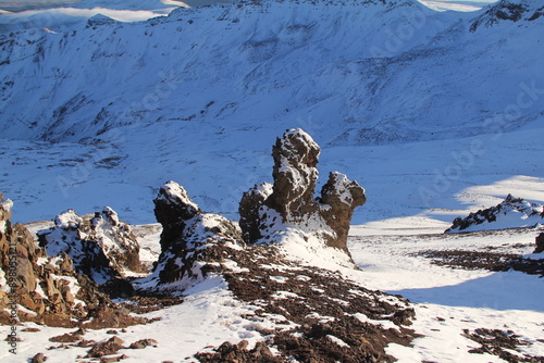 Sunlit rock formation on snow-covered volcano in Teide National Park, Tenerife, Canary Islands. The contrast between the warm-colored rock and the snowy mountainside creates a stunning visual display. photo