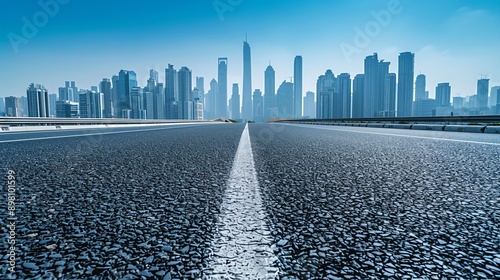 Empty highway leading towards a city skyline.