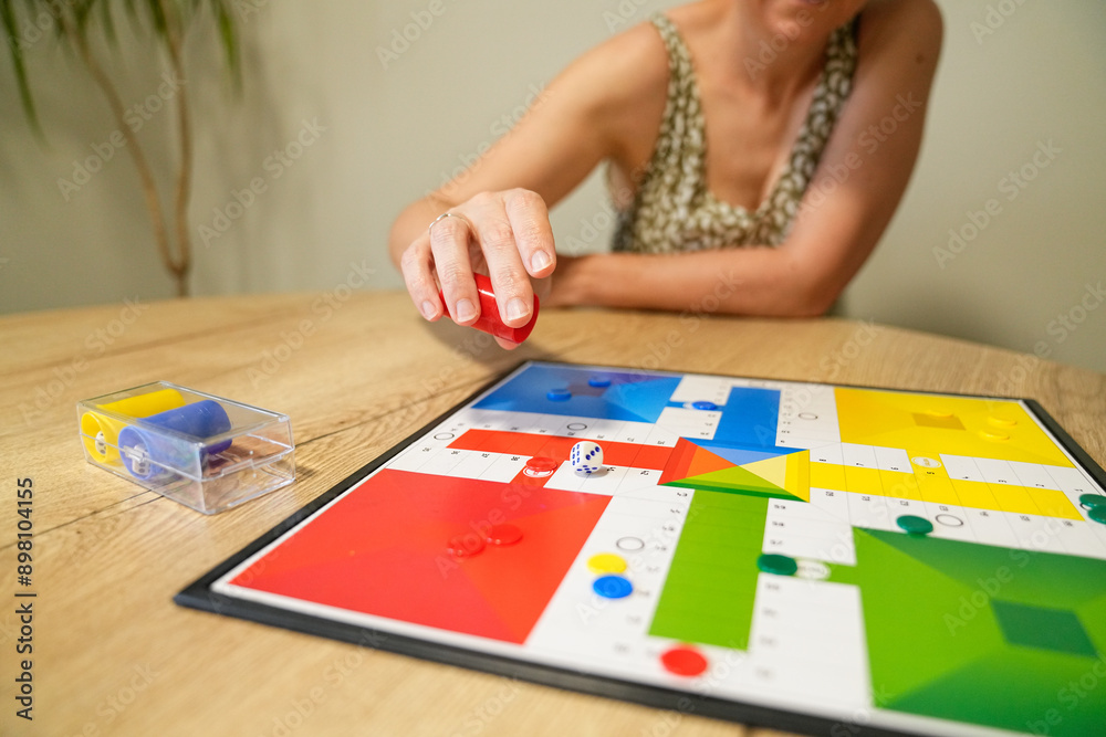 Obraz premium Mother moving game piece during board game with son at table