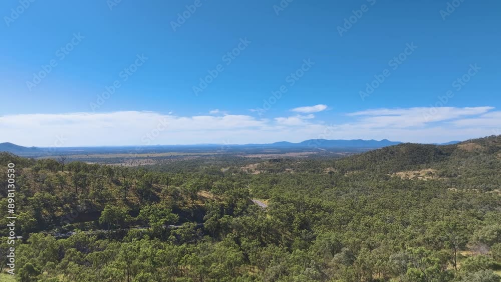 Aerial down the valley below Leydens Hill over the curling bends of the Burnett Highway across the verdant expanse of Rockhampton's vast plains. Queensland Australia Aerial down the valley below Leydens Hill over the curling bends of the Burnett Highway across the verdant expanse of Rockhampton's vast plains. Queensland Australia