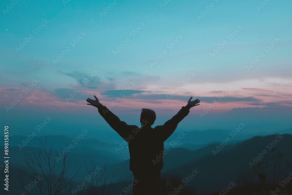 Man with his arms raised in the sky blue and pink sunset sky with mountains on top of it. Man with his arms raised in the sky blue and pink sunset sky with mountains on top of it.