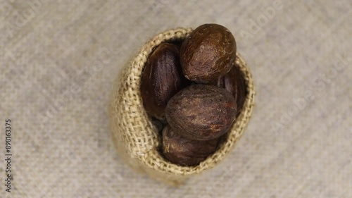 Close-up of a nutmeg, rotation on a black background. Various Indian Spices of rotation black background. photo