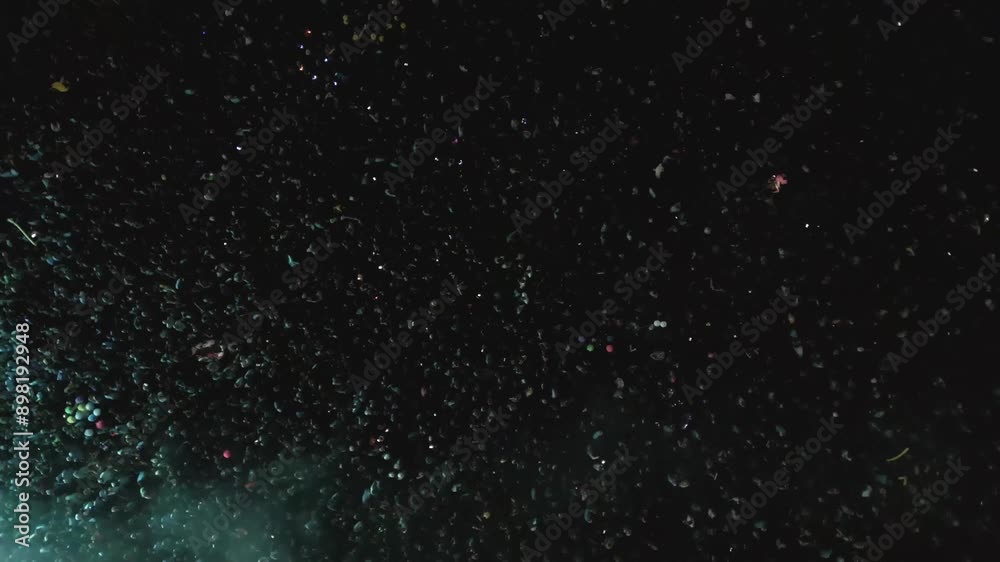 Aerial view of a large group of audience enjoying the concert, at night. Drone flying in circular motion, over the throng.