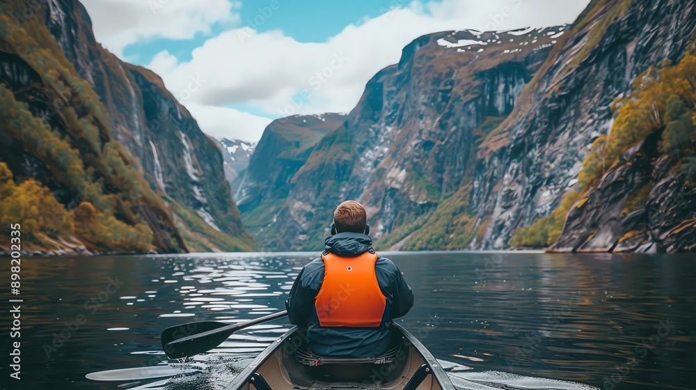 Man paddling canoe in a Norwegian fjord. Man paddling canoe in a Norwegian fjord.