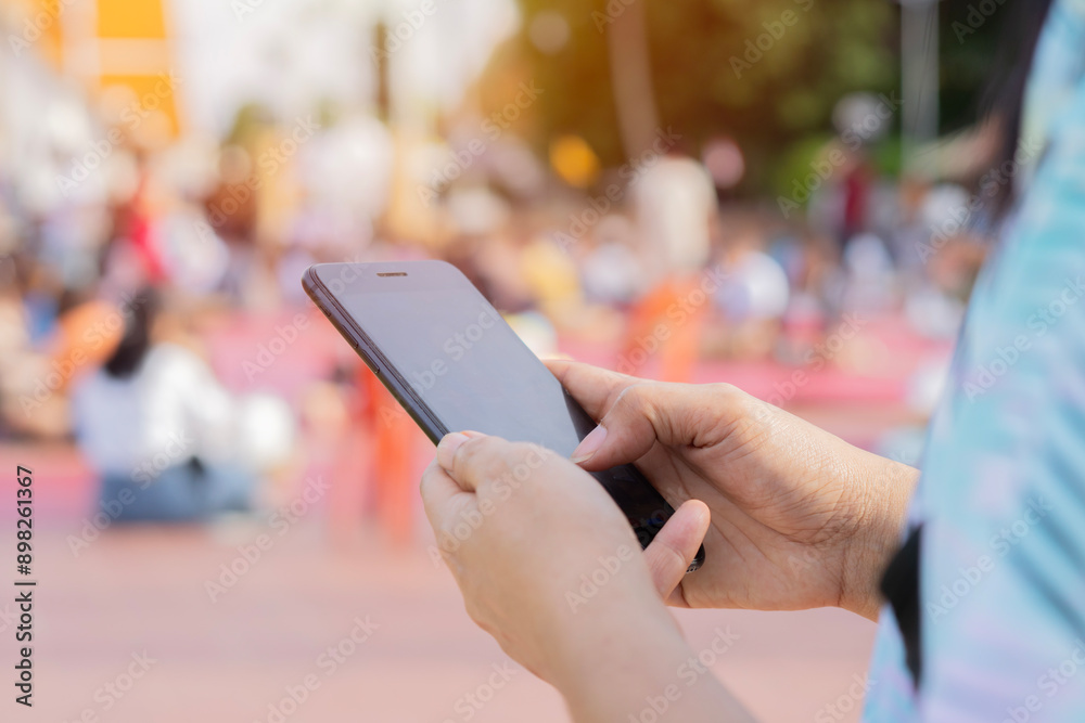 Close-up image of female hands using smartphone at city shopping street Close-up image of female hands using smartphone at city shopping street