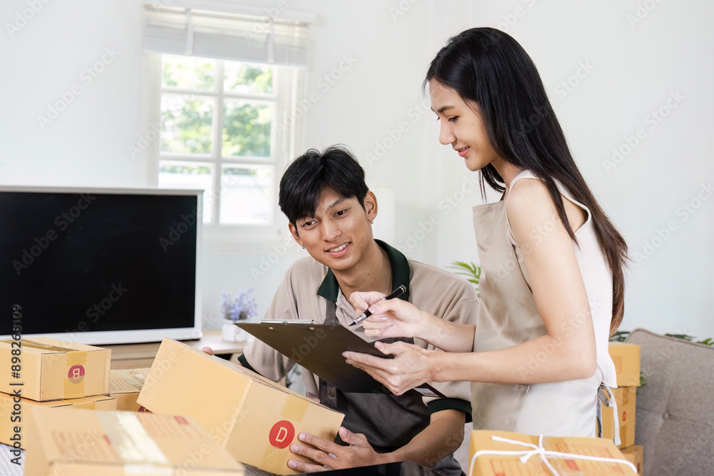 Fototapeta premium e-commerce business is writing a list of customers on paper, Business woman run an e-commerce business on website and social media. Selling product online