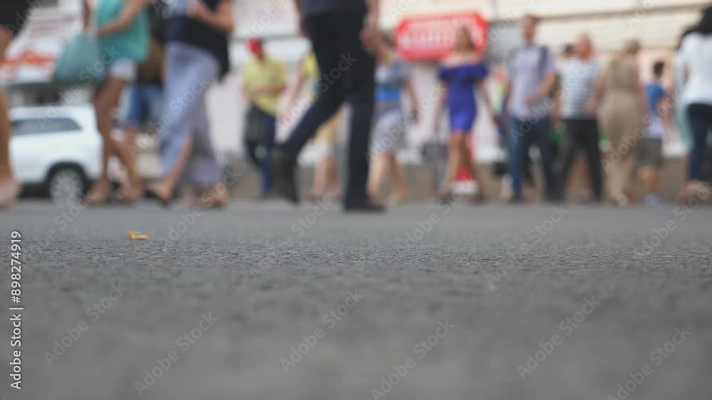 Low angle view of unrecognizable pedestrians crossing intersection in big city at summer day. Crowd of people walking a crosswalk in downtown. Concept of urban lifestyle. Blurred motion. Slow motion