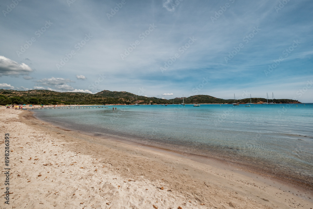 Obraz premium Holidaymakers enjoying the sun, sand and azure Mediterranean sea at Rondinara beach on the south east coast of the island of Corsica