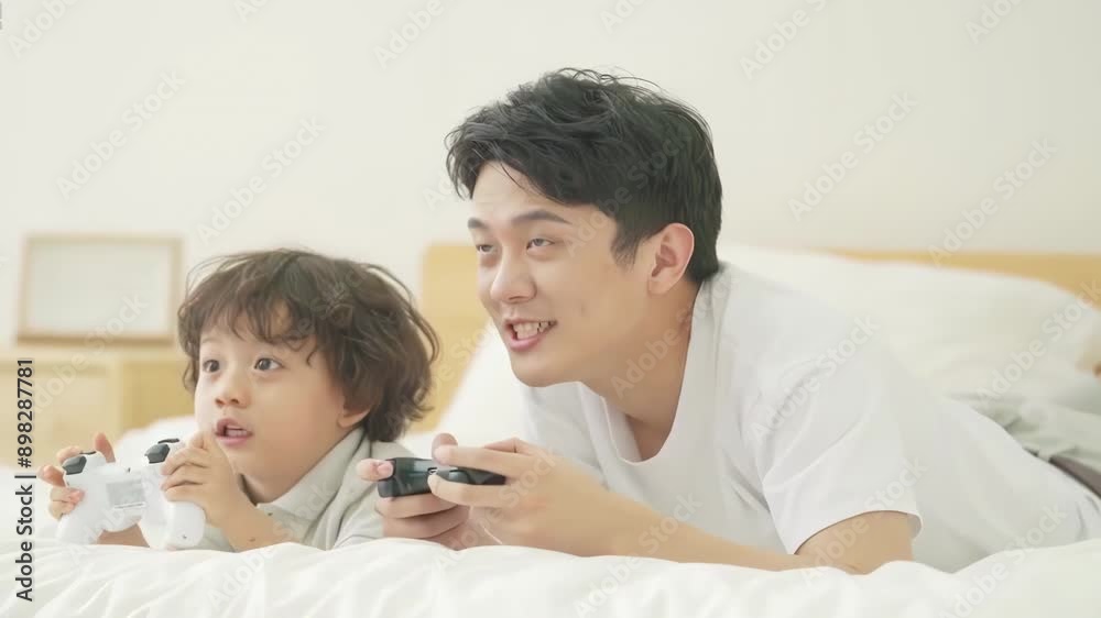 Happy family father, child son playing games and videos on bed at home joyful atmosphere enjoying leisure time in living room Happy family father, child son playing games and videos on bed at home joyful atmosphere enjoying leisure time in living room