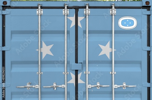 Micronesia flag depicted on metal doors of shipping cargo container outdoors in docks area close up photo