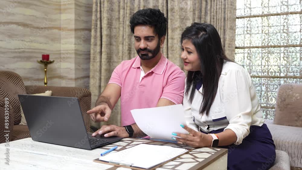 Young indian Couple using laptop manage domestic finance together sitting at home, count expenses, make budget control, review overdue loan payments. Investment, Tax and account. Young indian Couple using laptop manage domestic finance together sitting at home, count expenses, make budget control, review overdue loan payments. Investment, Tax and account.