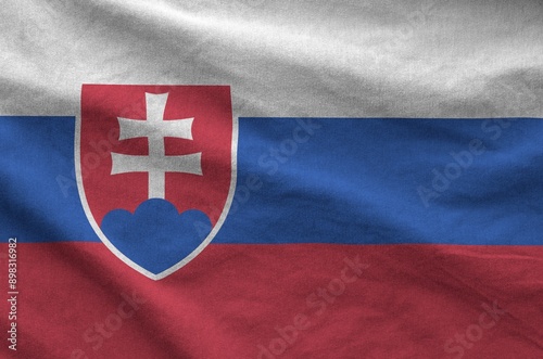 Slovakia flag depicted on folded wavy fabric of old cloth close up photo