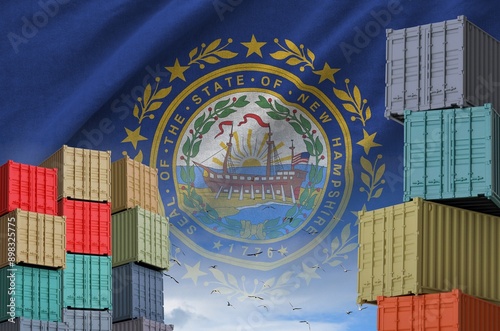 New Hampshire US state flag and big stack of shipping cargo containers in docks with sky background close up photo