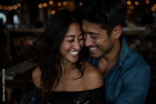 A couple embraces and shares warm smiles in a dimly-lit restaurant, emphasizing their affectionate bond and the intimate, cozy atmosphere of the dining experience.