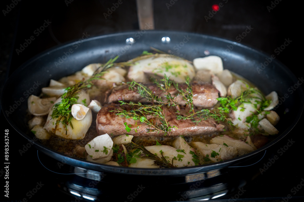 healthy and fres cooking at home - roasted deer tenderloin with and porcini mushrooms, onions, rosemary and thyme in a big pan healthy and fres cooking at home - roasted deer tenderloin with and porcini mushrooms, onions, rosemary and thyme in a big pan