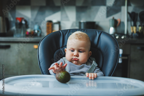 A baby boy eats a delicious avocado. The baby's first meal. The child eats an avocado