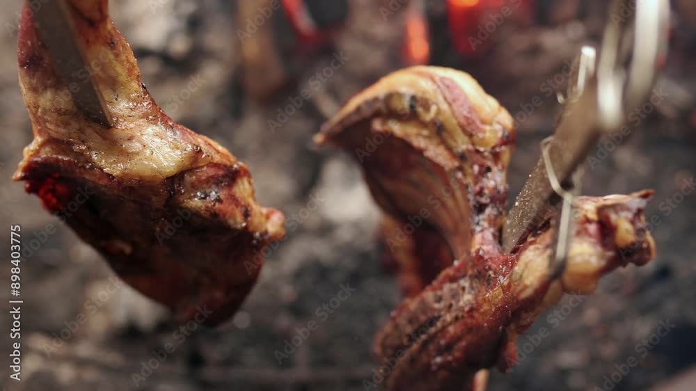Lamb meat inserted in a metal rod cooking on a bonfire. Lamb to the stake. Lamb meat inserted in a metal rod cooking on a bonfire. Lamb to the stake.