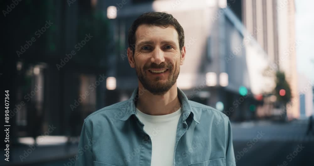 Handsome Caucasian Man Raises His Eyes and Smiles Warmly at the Camera on a Quiet City Street, Creating a Friendly and Inviting Urban Atmosphere. Handsome Caucasian Man Raises His Eyes and Smiles Warmly at the Camera on a Quiet City Street, Creating a Friendly and Inviting Urban Atmosphere.