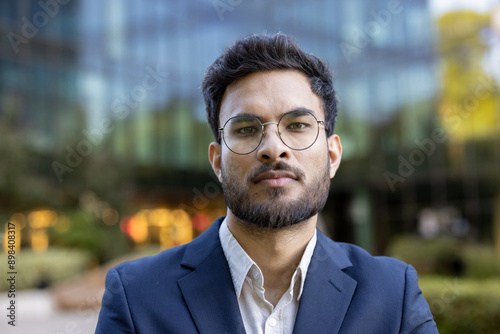 Wallpaper Mural Confident business professional wearing glasses and formal suit standing outdoors in front of modern office building. Serious expression conveys determination and focus. Concept of leadership Torontodigital.ca