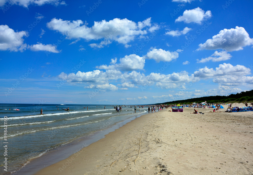 nadmorska plaża z piaskiem i błekitne niebo z chmurami, Sunny beach with blue sky and white clouds