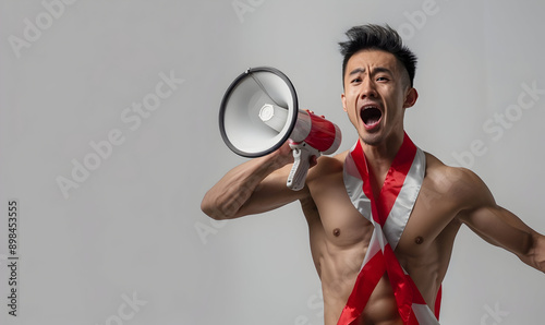 Asian man shirtless wearing red white flag ribborn and megaphone for indonesia independence photo