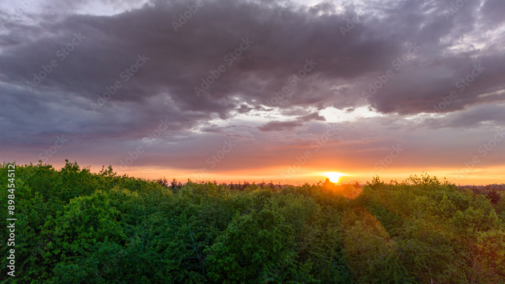 Vue aérienne du coucher de soleil sur fond dramatique très nuageux et orageux au milieu des champs et des forêts du bocage normand en France Vue aérienne du coucher de soleil sur fond dramatique très nuageux et orageux au milieu des champs et des forêts du bocage normand en France
