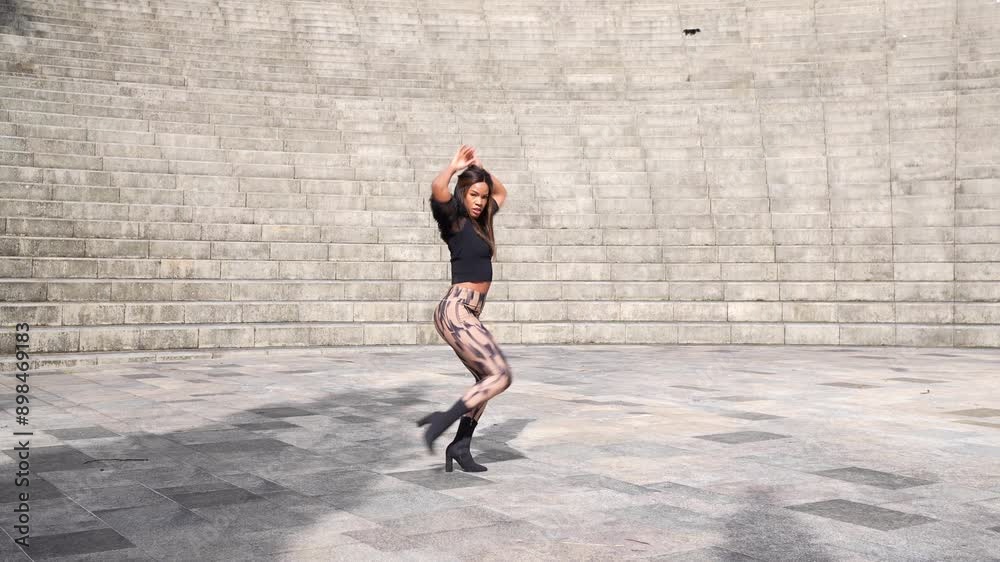 Horizontal three quarter length video of a woman raising arm sensually dancing cuban salsa outdoors Horizontal three quarter length video of a woman raising arm sensually dancing cuban salsa outdoors