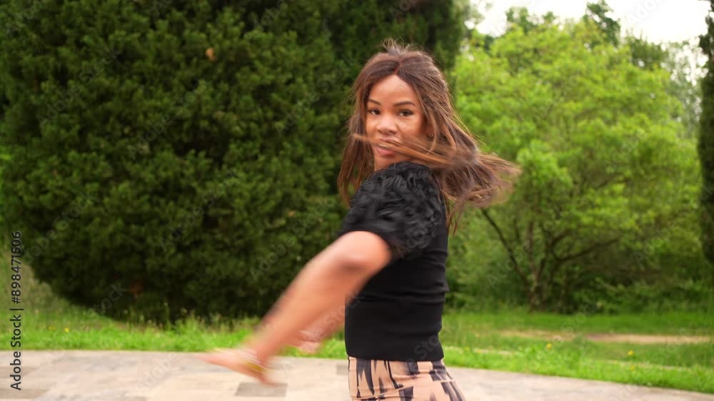 Low angle view portrait of a happy passionate latin woman dancing salsa alone in a park Low angle view portrait of a happy passionate latin woman dancing salsa alone in a park