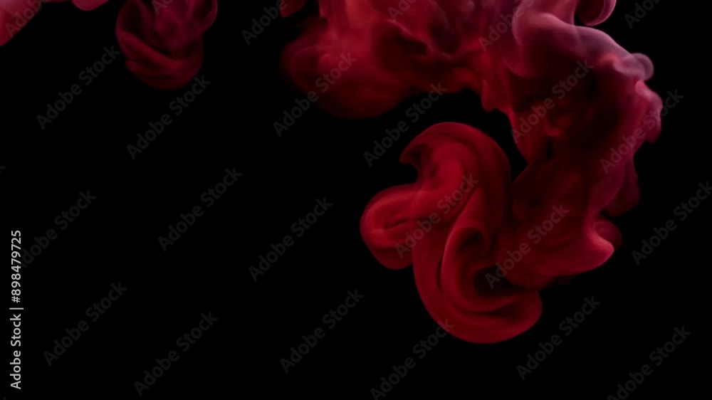 Swirling Red Smoke Forming Abstract Patterns in Darkness.
