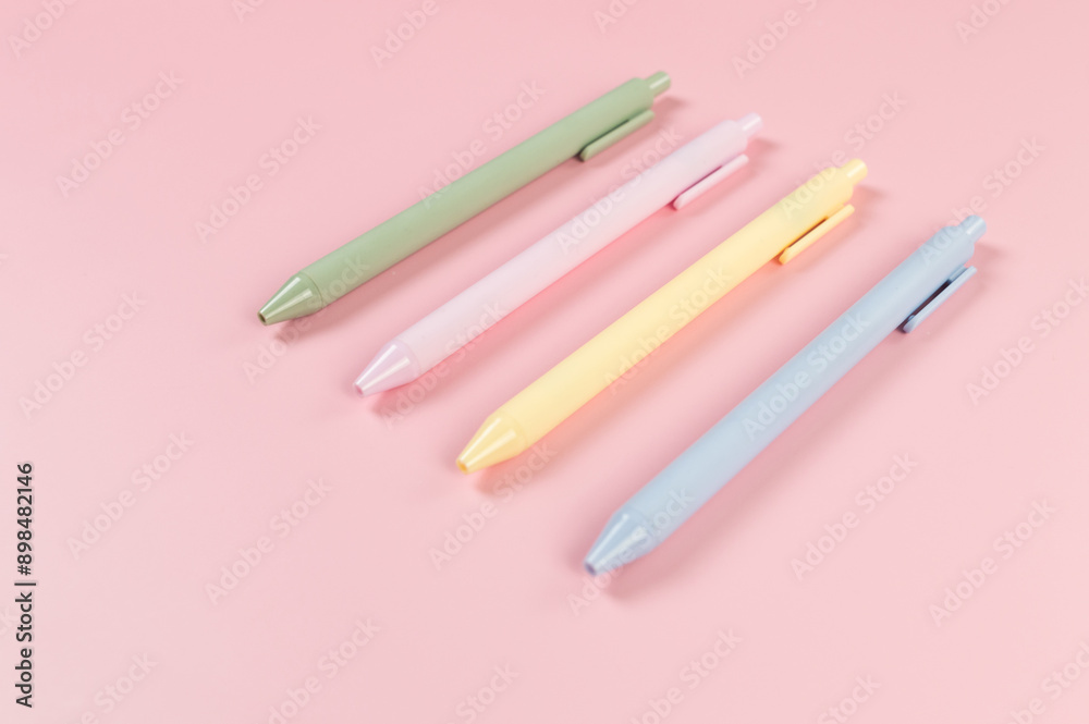 Top view of colorful pens on pink background. School, office wallpaper. Flat lay, copy space.