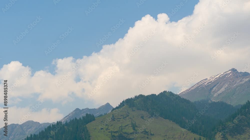 4K Zoom out timelapse of white fluffy clouds moving over mountains at Burwa, Himachal Pradesh, India. Green Himalaya mountains on a bright summer day with blue sky. 4K Zoom out timelapse of white fluffy clouds moving over mountains at Burwa, Himachal Pradesh, India. Green Himalaya mountains on a bright summer day with blue sky.