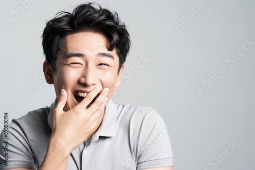 Happy young man in studio listening to a hilarious, comedy, or comic joke. Happy, jovial, attractive Indian man with humorous personality from white background