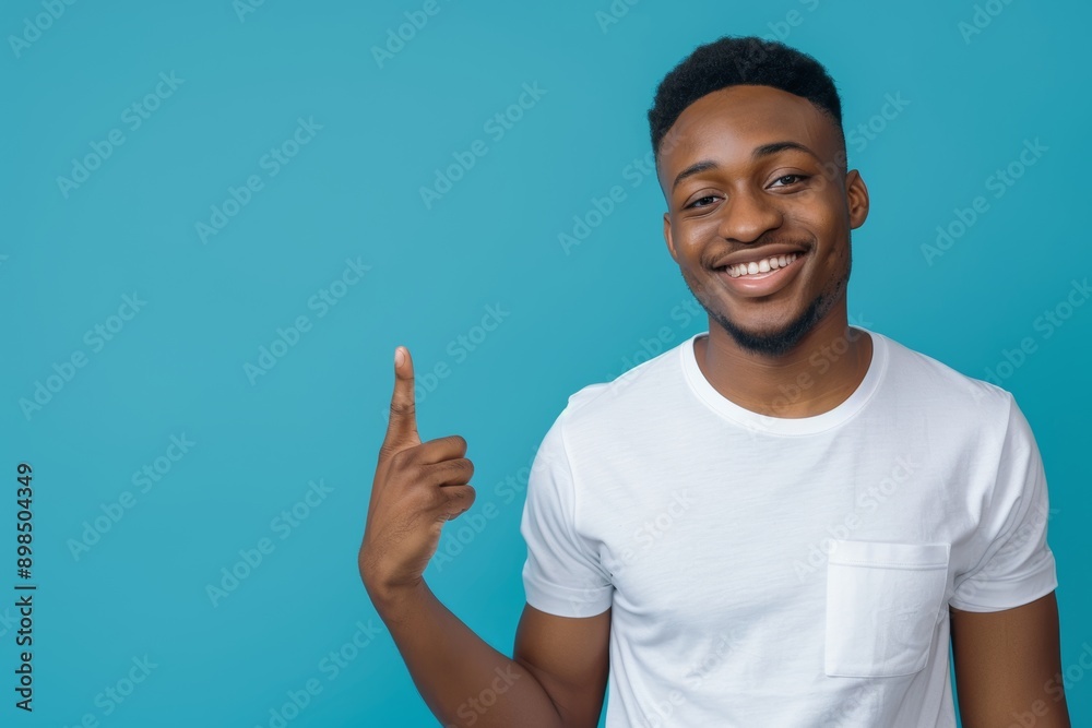 Posed man with a smile, contemplating, and option on a blue studio background. Man, decision, or model with product placement, hand gesture, sign, and showing Posed man with a smile, contemplating, and option on a blue studio background. Man, decision, or model with product placement, hand gesture, sign, and showing