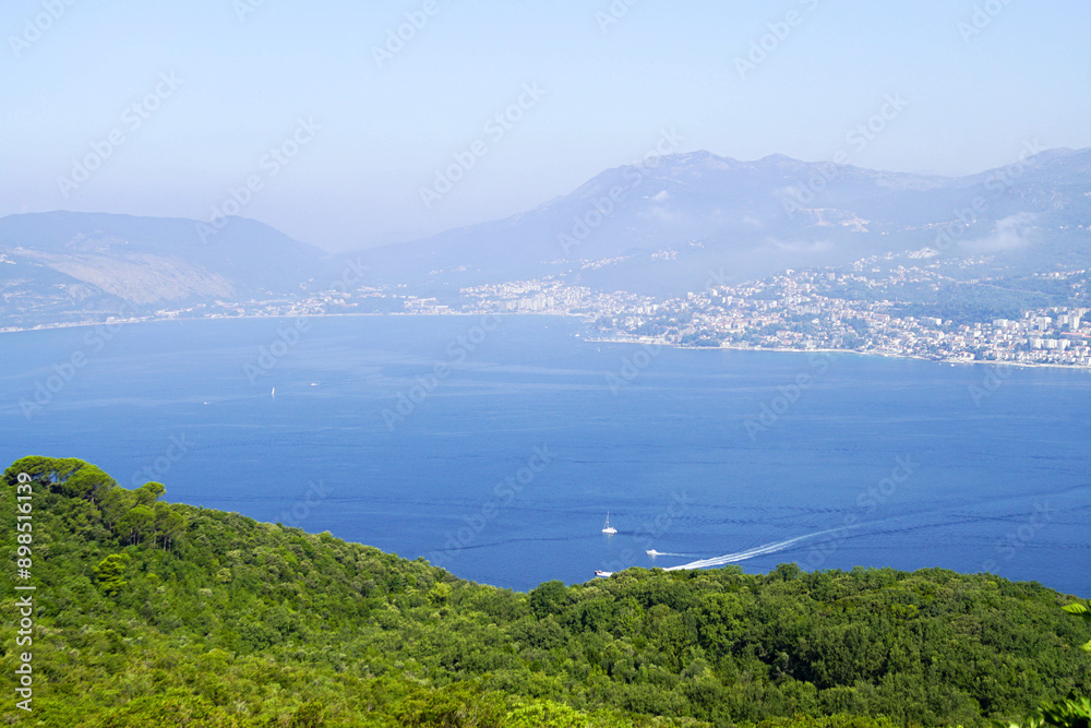 View towards the city of Herceg Novi from a viewpoint in the village of Klinci on the Lustica Peninsula (Montenegro). Overview of the Herceg Novi part of the Bay of Kotor on a sunny summer day. View towards the city of Herceg Novi from a viewpoint in the village of Klinci on the Lustica Peninsula (Montenegro). Overview of the Herceg Novi part of the Bay of Kotor on a sunny summer day.