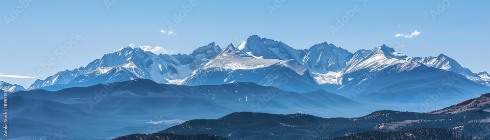 Fototapeta premium A majestic mountain range with snowcapped peaks under a clear, blue sky