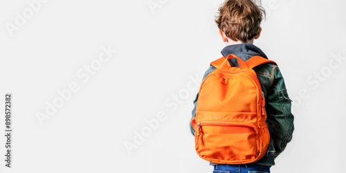  young boy wearing a backpack is seen from behind on a white background with copy space for text. back to school concept.