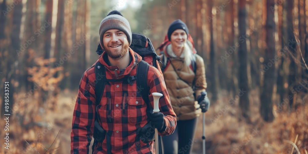 Photo of a young couple hiking on a nature trail, smiling and holding walking poles. Hiking and outdoor adventure concept. Photo of a young couple hiking on a nature trail, smiling and holding walking poles. Hiking and outdoor adventure concept.