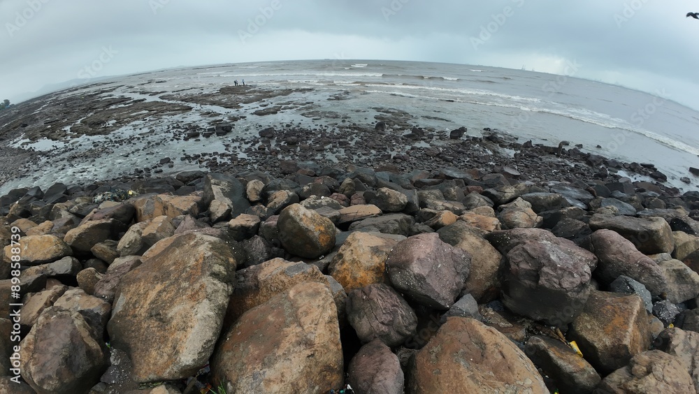 A picturesque landscape featuring a rocky beach shore, the sea gently lapping at the rocks beneath a bright sky. A picturesque landscape featuring a rocky beach shore, the sea gently lapping at the rocks beneath a bright sky.
