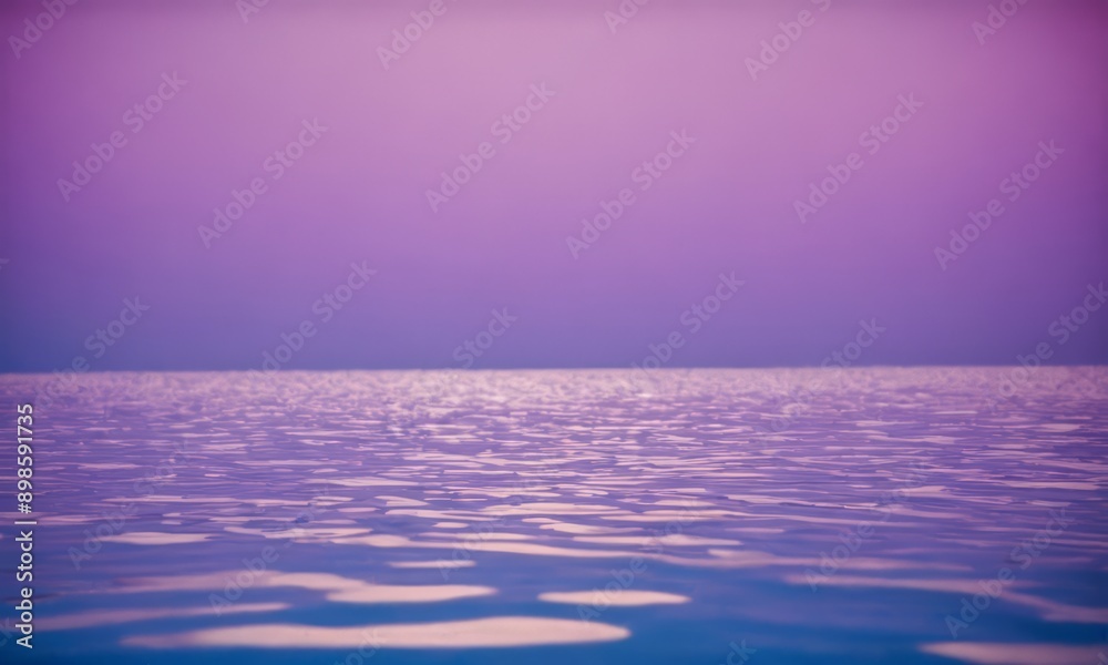 Obraz premium photograph of a body of water with a purple and blue color scheme, featuring a reflection of the sky and clouds.