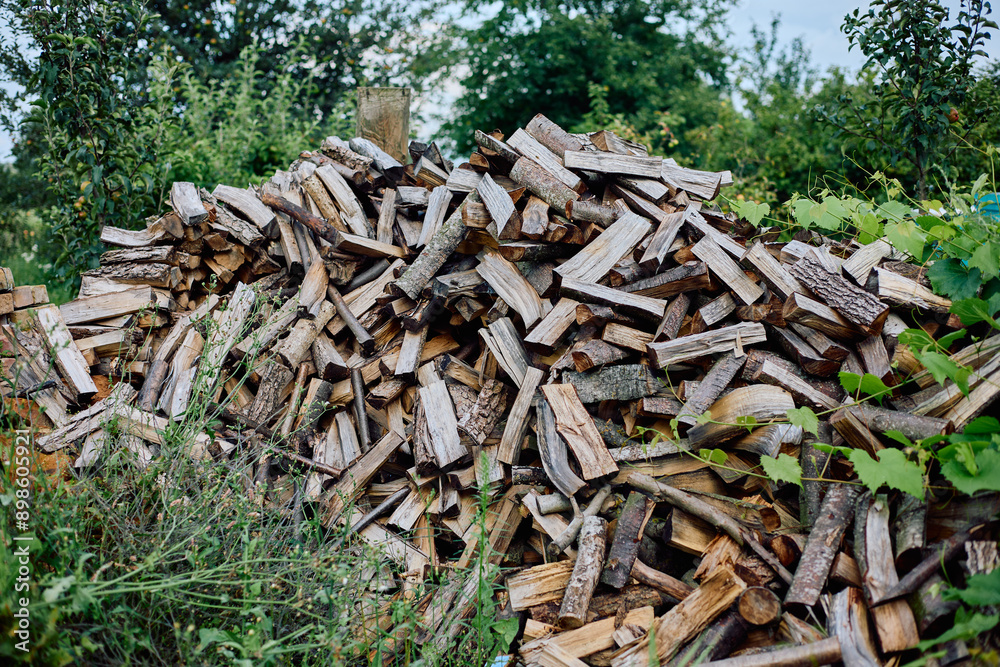 A pile of chopped firewood in the garden in the country A pile of chopped firewood in the garden in the country