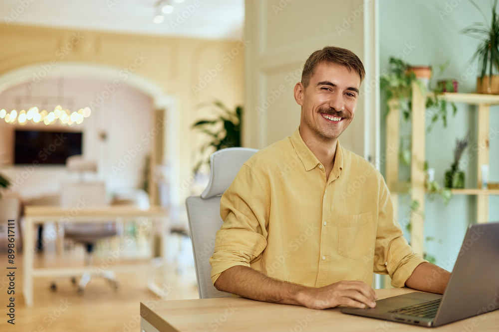 Portrait of a smiling freelance man, working over the laptop, in the co-working space. Portrait of a smiling freelance man, working over the laptop, in the co-working space.
